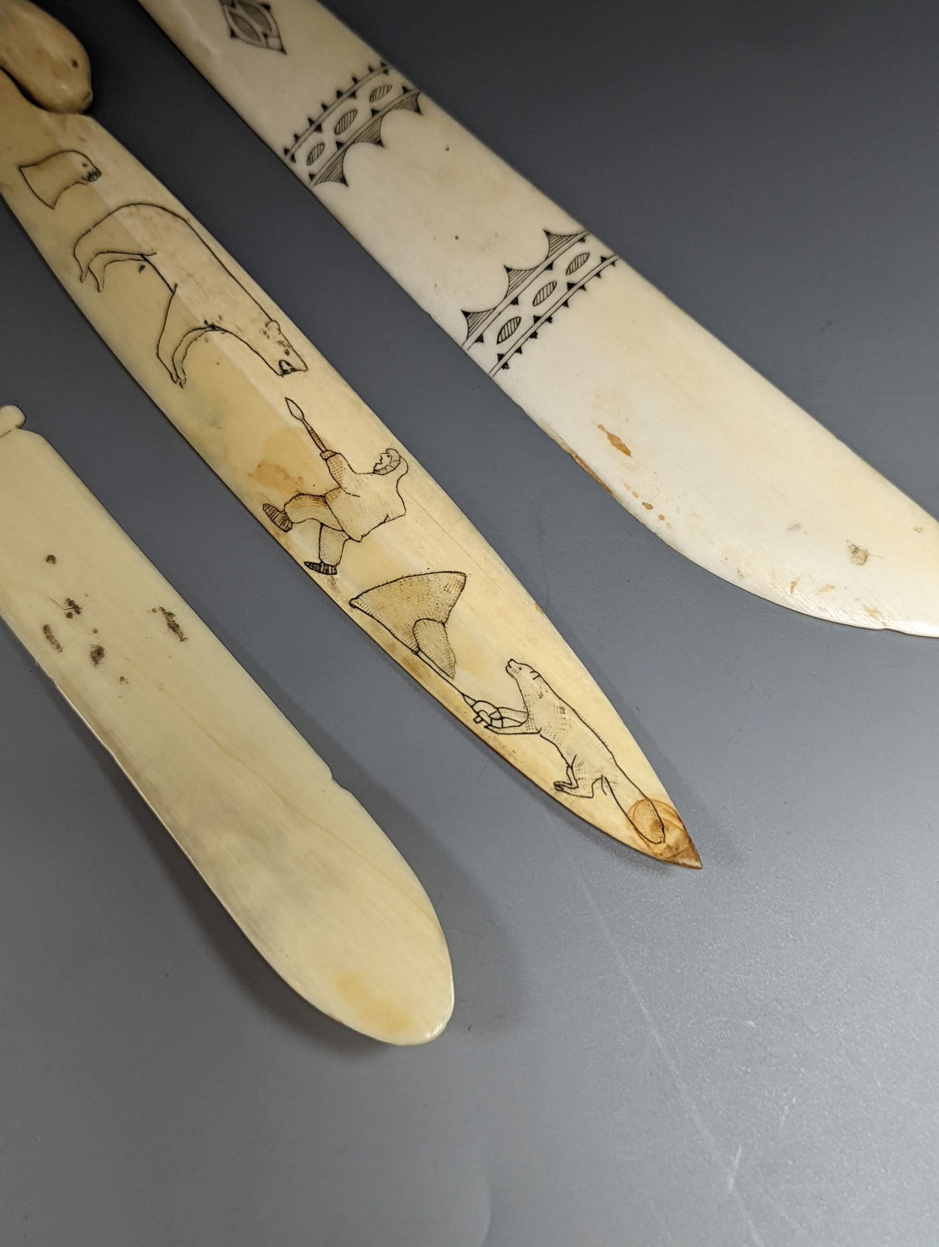 A 19th century Scrimshaw seal paperknife, 22cm., and two other engraved bone paperknives